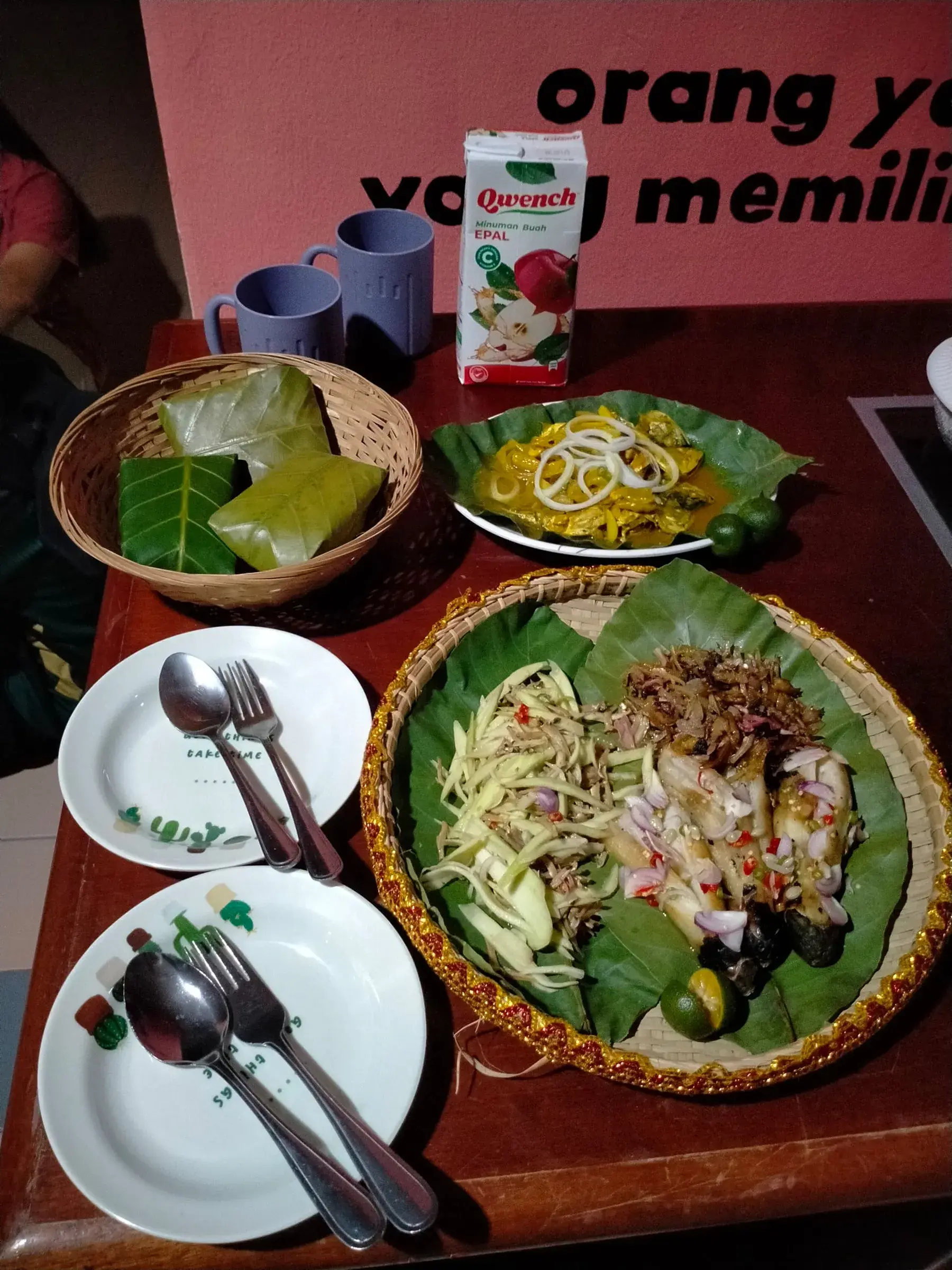 A traditional Kadazandusun meal of leaf-wrapped rice parcels and side dishes on banana leaves