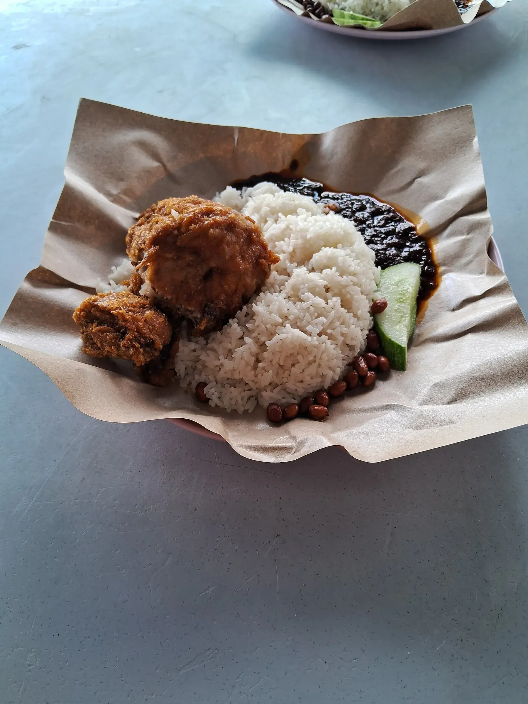 Nasi lemak with fried chicken, sambal, cucumber and peanuts